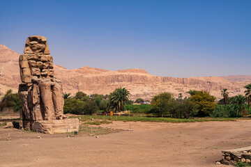 One of the huge Colossi of Memnon on whose back is The Valley of the Artisans. Photograph taken in...