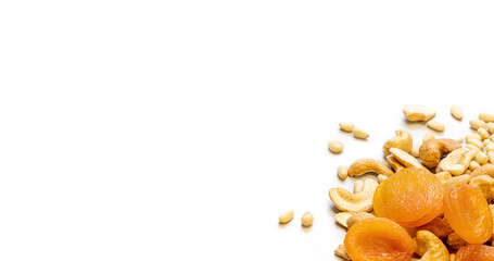 White background with dried apricots, cashews and pine nuts in the lower right corner. Healthy food concept. Copy space