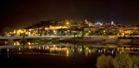 Night And Panoramic Photography Of The Muslim Fortification La Alcazaba, Located In The Spanish City Of Badajoz-Extremadura. Christian Medieval Castle Reflected In The Guadiana River