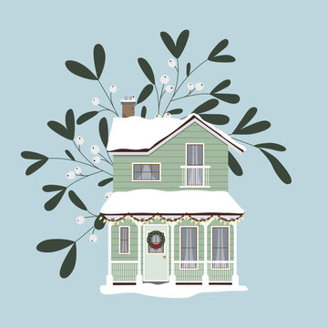 Zimowy domek, śnieg i jemioła. Dom ozdobiony na Święta Bożego Narodzenia i Nowy Rok. Nowoczesny zielony rodzinny dom ze spadzistym dachem, oknami, drzwiami i białymi poręczami. Urocza chatka.