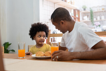 African American Father talking with his boy at dining table
