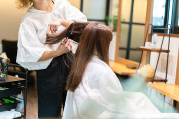 美容室で髪をカットする女性