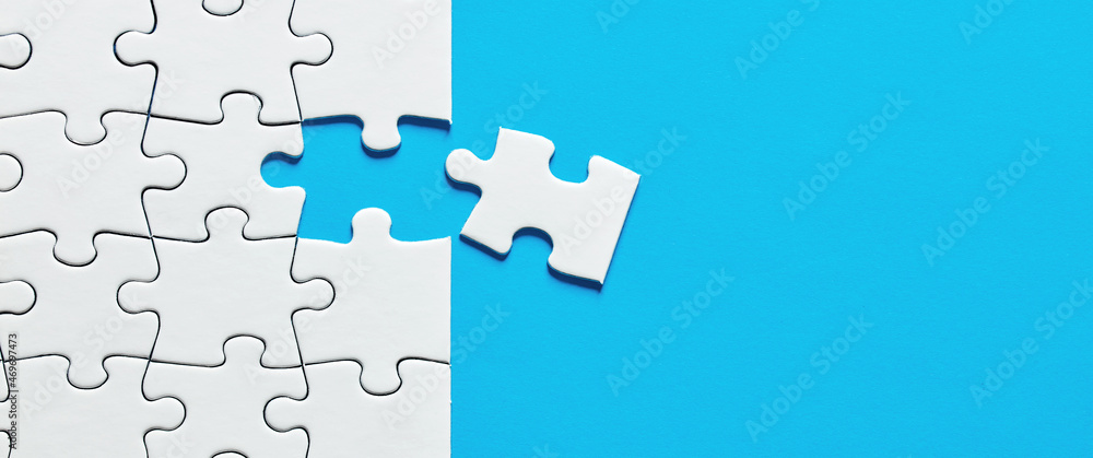 Poster one missing puzzle piece on blue background with copy space.