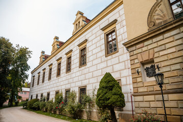 Obraz premium Castolovice, Eastern Bohemia, Czech Republic, 11 September 2021: renaissance castle with tower at sunny day, courtyard with arcades and geometric flower beds, murals and sgraffito plaster on walls