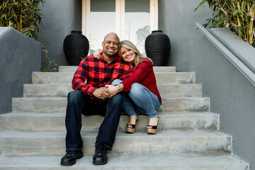 Happy married couple holding hands on the front porch