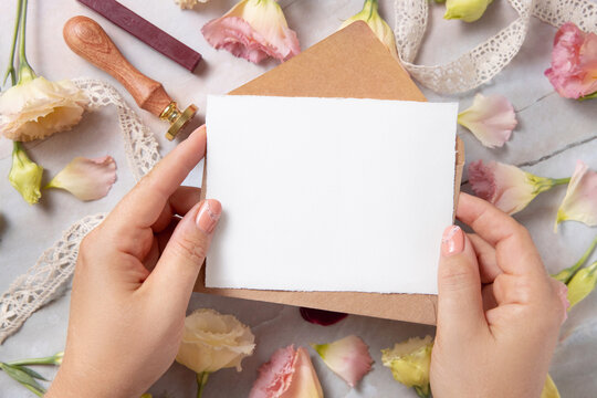 Hand With Card And Envelope With Pink Flowers And Ribbons