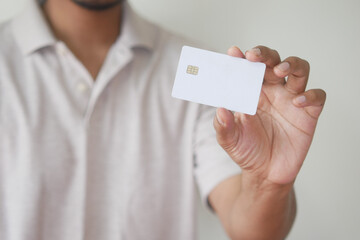 Man in casual dress showing credit card 