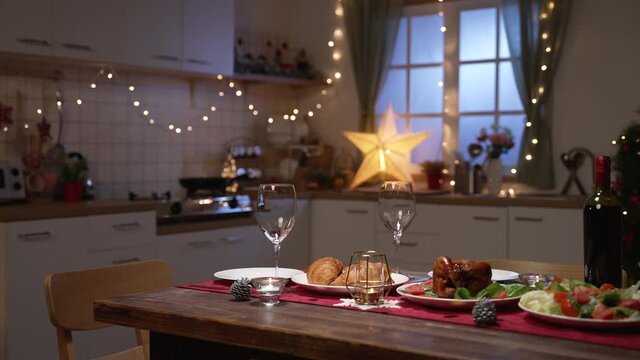 elegant evening dinner table setting in celebration of valentines&rsquo; day with champagne at home with Christmas tree and lights on background