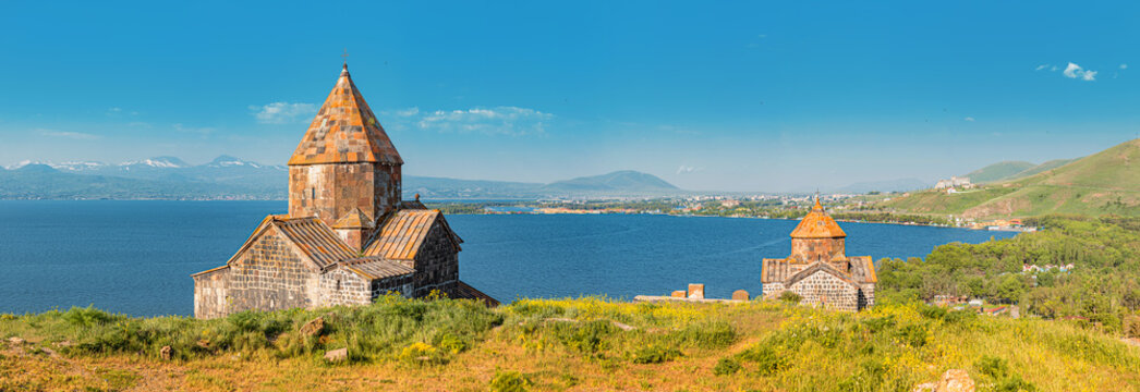 Panorama from the peninsula viewpoint to Sevanavank Monastery and chapel overlooking famous Sevan lake at sunny weather
