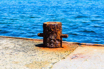 Old rusty mooring bollard at pier