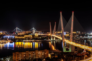 View of Vladivostok at night with the Golden Bridge and the Bridge Russian on the horizon. Far East, Russia