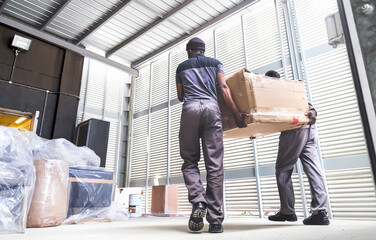 Men delivering boxes from a truck. Furniture delivery.