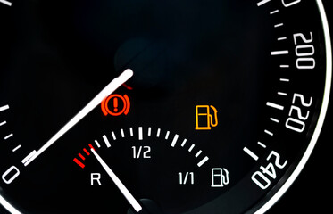 Low fuel readings on car dashboard. Fuel level indicator in reserve, no fuel
