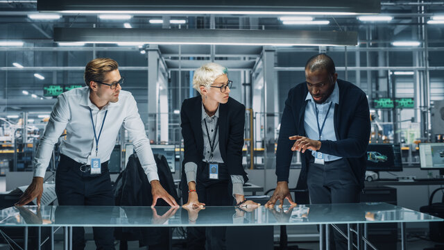 Diverse Team of Automotive Engineers Working in Office at Car Factory. Industrial Designers Talk and Discuss Invisible Object Made in Augmented Reality. Great Template for Your AR Objects