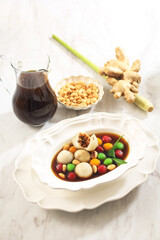 Wedang Ronde (Tangyuan) or Glutinous Sweet Balls Dumpling in Ginger Infused Palm Sugar Syrup. Topping with Roasted Peanuts. Copy Space