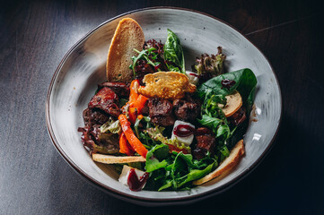 Warm salad mix with chicken liver and crouton. Restaurant food.