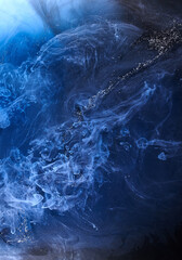 Blue smoke on black ink background, colorful fog, abstract swirling ocean sea, acrylic paint pigment underwater