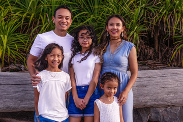 family, leisure and people concept-young active parents with three daughters - enjoying summer vacation together. Big asian happy family of five.