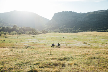 two people sitting in a chair looking at the mountain landscape