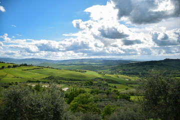 Tuscany, Italy, May 2018, a view from a height of a green valley with avenues of cypress trees
