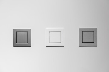 White and gray light switches on a white wall 
