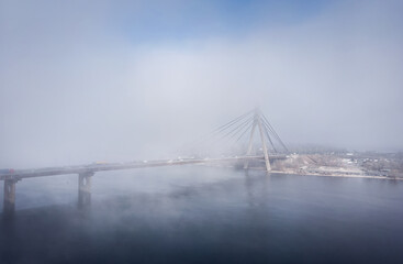 Foggy weather in the autumn, aerial view of bridge through the fog, traffic on the bridge in the fog