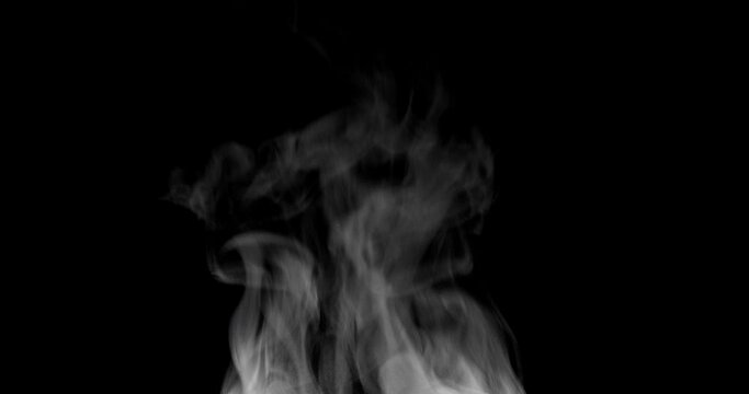 White steam isolated on black. Trickle of Steam Slowly Rising from the Cup. White steam rises graceful twists on a black background. Footage is perfect for the layer with different blending modes.