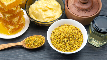 Fresh flower honey of different varieties, pollen and honeycomb with spoons on a wooden background....