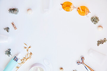 Dermatology cosmetics on white background. Trendy face care cosmetics background. Serum, patches, massager and sunglasses. Natural eco forest moss and oats. Hyaluronic and moisturizing gel. 