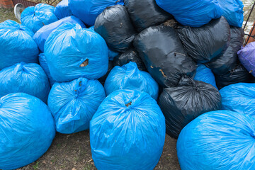 Garbage bags in black and blue lie in a pile
