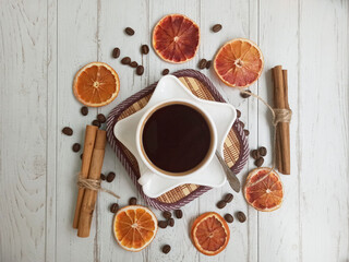 Cup of coffee with cinnamon sticks and dried oranges isolated on white background. Christmas coffee. Winter still life.