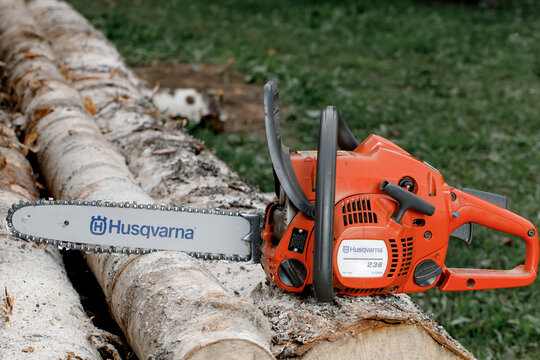 Kirov, Russia - 09.10.2020 Husqvarna 236 chainsaw stands on logs. global brand of garden equipment