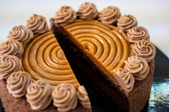 Slicing a delicious and gorgeous fancy chocolate caramel cake.