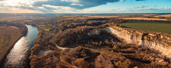 Aerial photo of abandoned chalk quarry near the river. Beautiful landscape of high cliff near the river in countryside