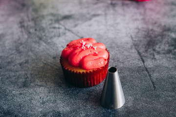Delicious cupcakes. Cupcakes and confectionery attachments for cream. Cupcakes on a concrete table 