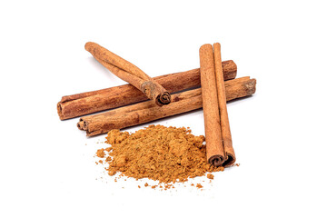 Herb, heap of dried cinnamon bark and powdered cinnamon, isolated on a white background.