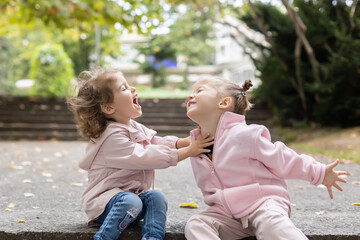 Two little girls having fun in the park. Happy childhood