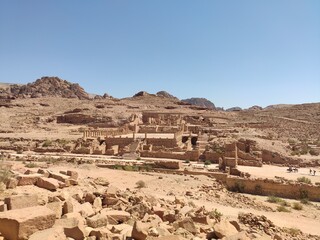 La cité nabatéenne Petra, située au sud de l'actuelle Jordanie, ancien chemin et historique de transport ou vente de produits, forte chaleur, grand chemin de sable, vue ensemble du site et des ruines 