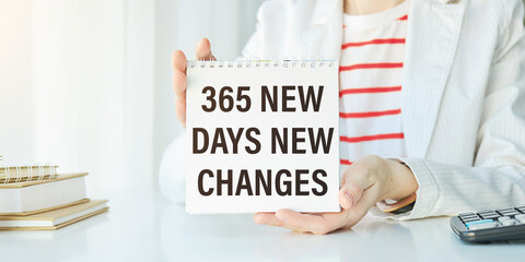 365 NEW DAY, 365 NEW CHANCE written in a notebook in hands. Concept business and finance.