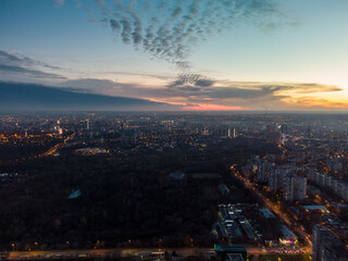 Fototapeta na wymiar Aerial view Kharkiv city center recreation park Sarzhyn Yar with night lights on streets of residential district, scenic sunset view with epic skyscape