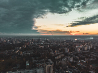 Fototapeta na wymiar Aerial sunset evening view on residential Kharkiv city Pavlove Pole district. Multistory buildings with scenic cloudy sky and orange sun on horizon. Color graded