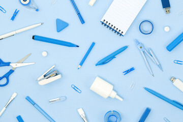 Assorted office and school white and blue stationery and notepad on blue monochrome background....