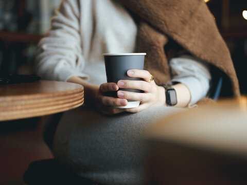 カフェでコーヒーを持つ女性