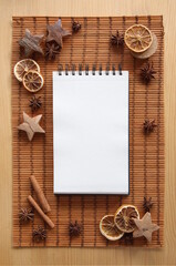Christmas background with white paper sheet, festive mock up composition with aromatic star anise, cinnamon, slices of orange