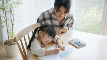 家でお絵描きする3歳の子供と母親（育児・子育て）