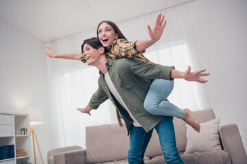 Photo of attractive excited young couple wear casual outfits smiling arms sides flying spending...