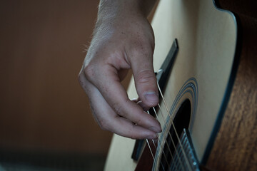 Hand playing on a guitar.