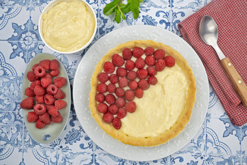 préparation d'une délicieuse tarte aux framboises entières, ingrédients sur table