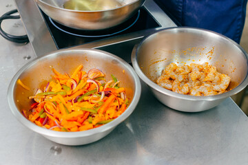 Photo of two bowls with marinated shrimps and fryed vegetables, preparing process concept