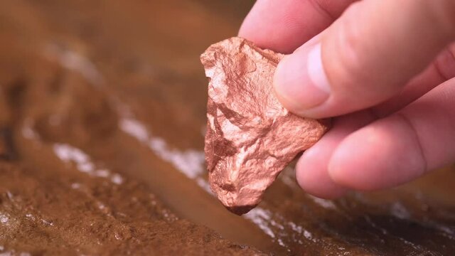 Miners hold in their hands copper minerals found in the mine for inspection and consideration.